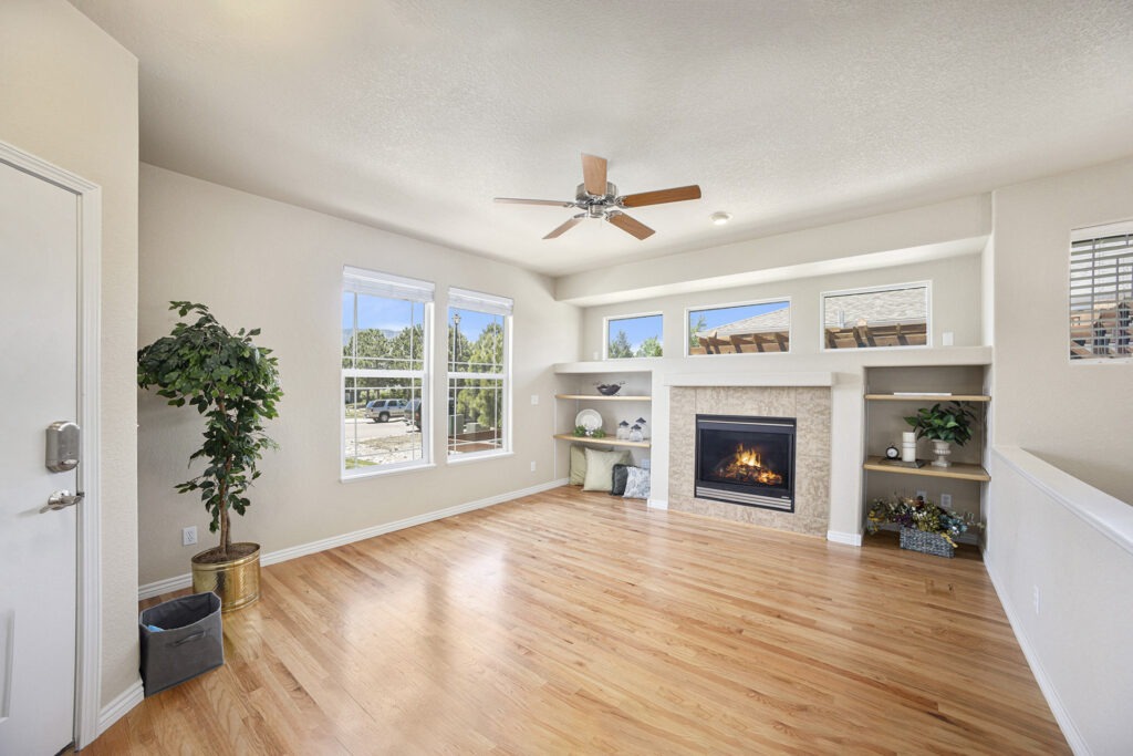Updated living room with wood floors, a gas fireplace, and abundant natural light.