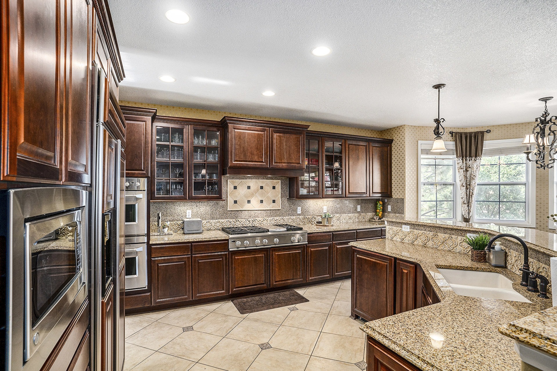 Large open kitchen with wood cabinets, built-in gas stove, and dual ovens.