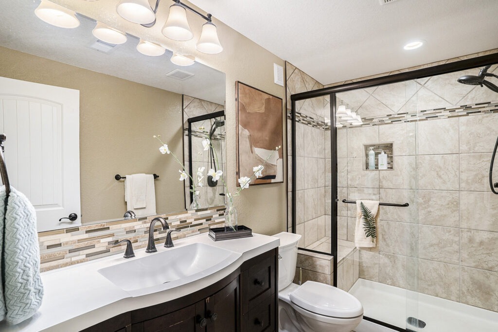 Updated full bathroom with a walk-in shower, modern fixtures, and a freestanding vanity.