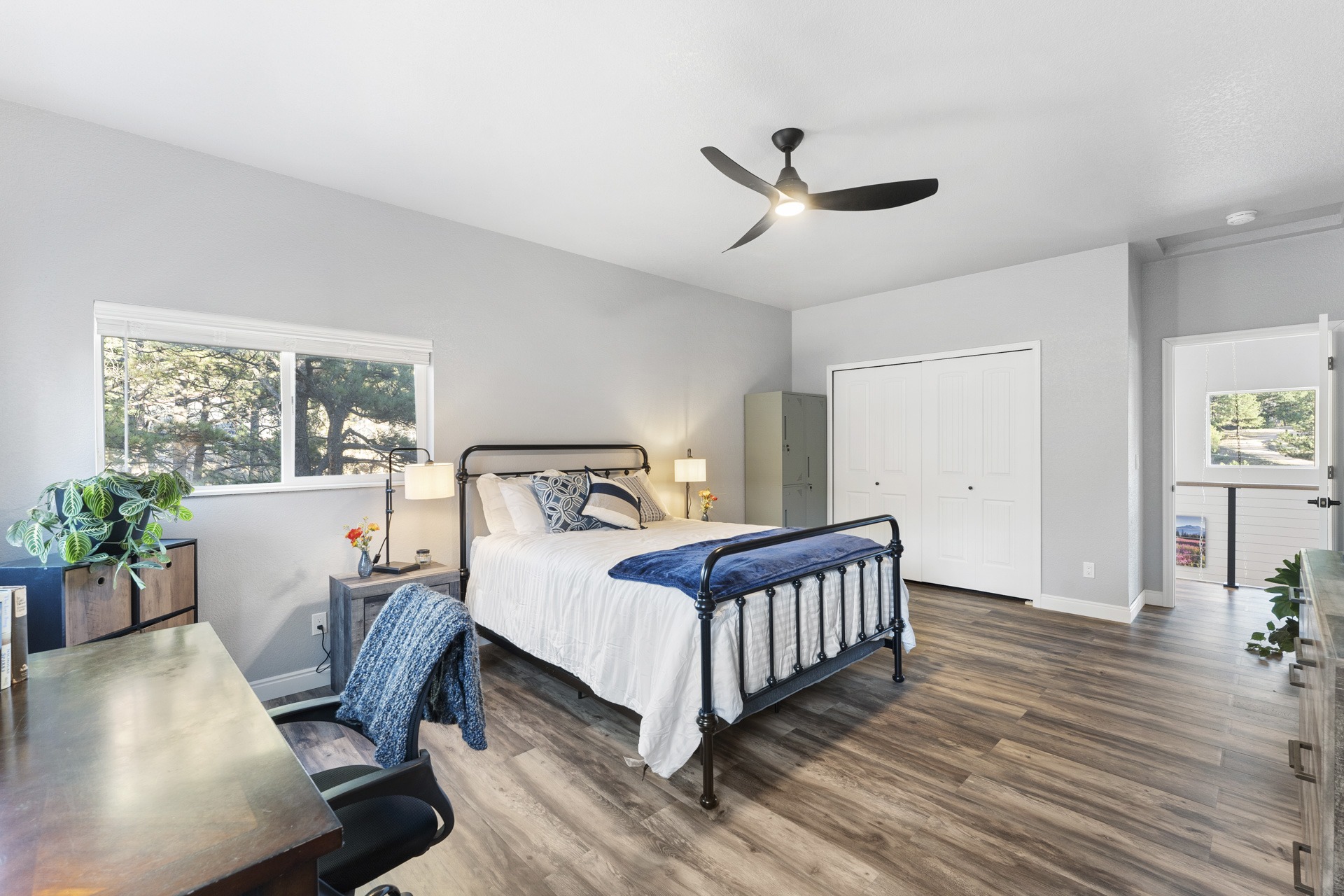 HDR photo of a bedroom in a Colorado mountain home with wood floors and a ceiling fan.