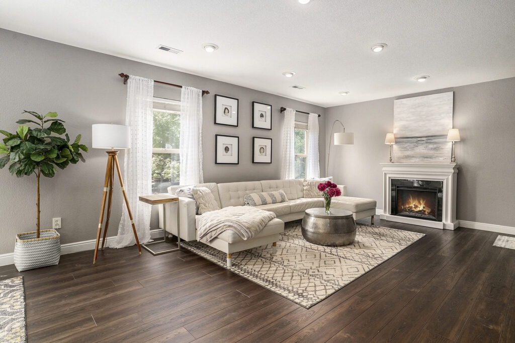 Modern living room with a fireplace and dark hardwood floors, featuring a sleek and elegant design.