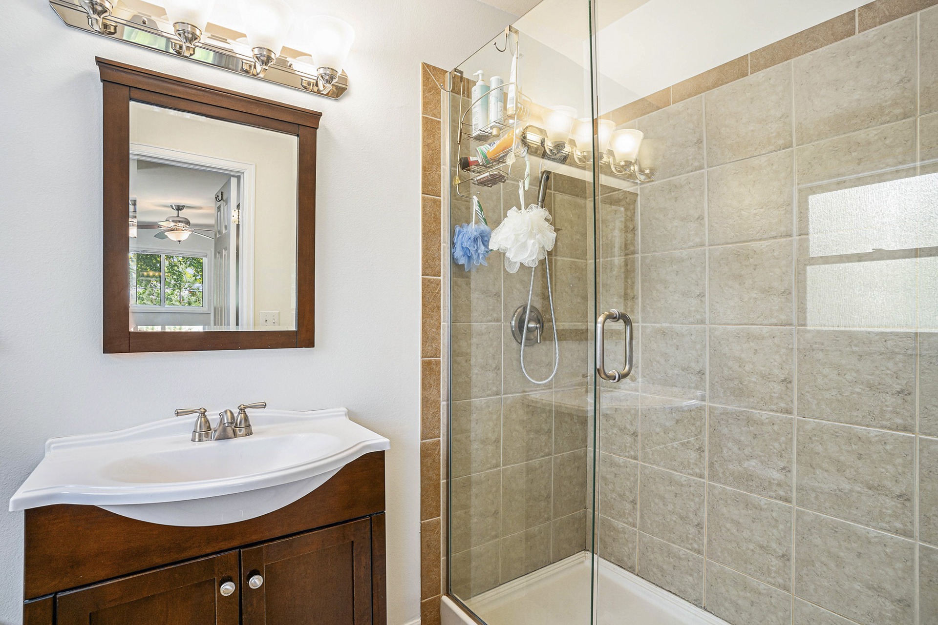 Updated bathroom with a walk-in shower, modern vanity, and contemporary lighting.