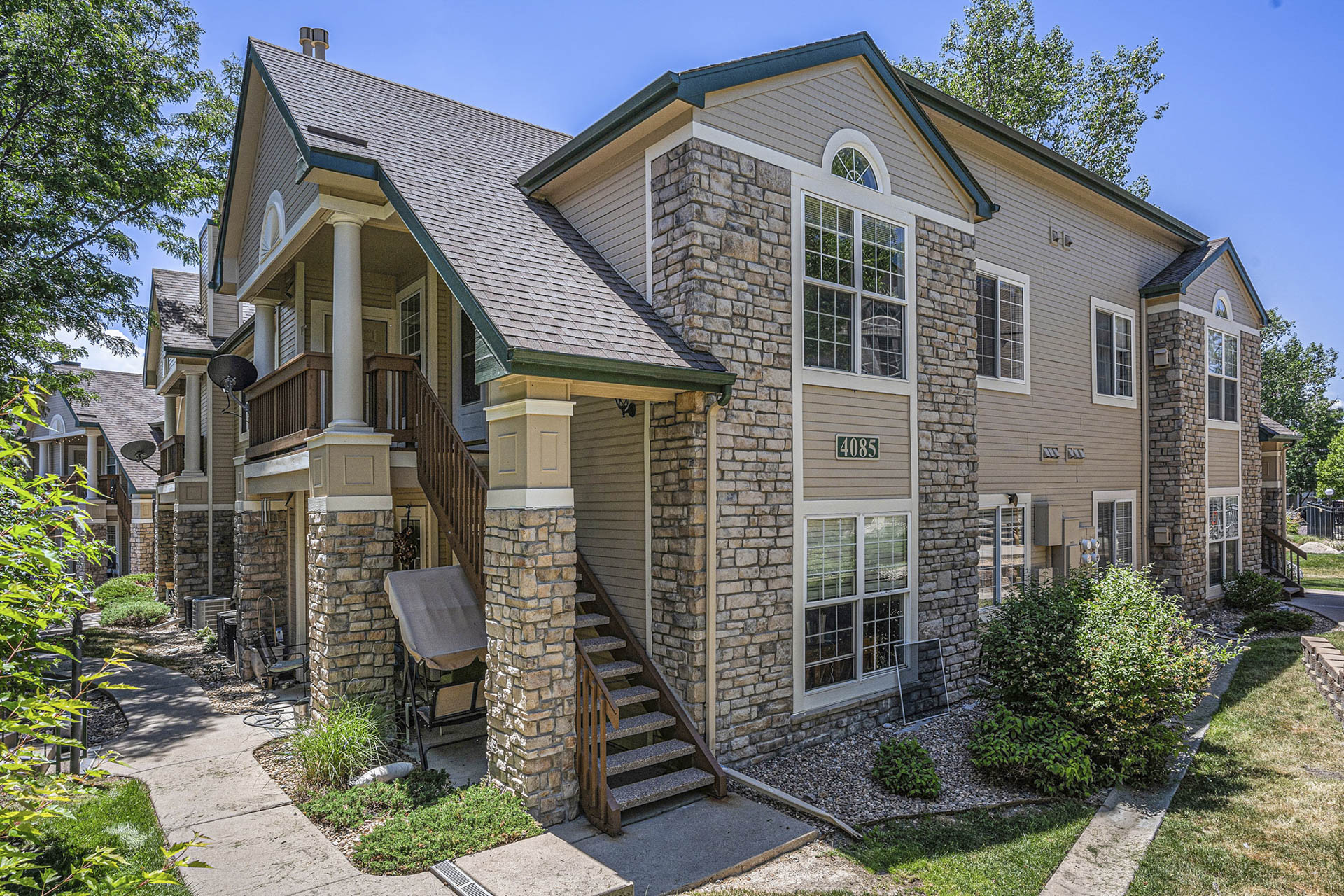 Exterior of a two-story condo building with modern architecture and landscaped surroundings.