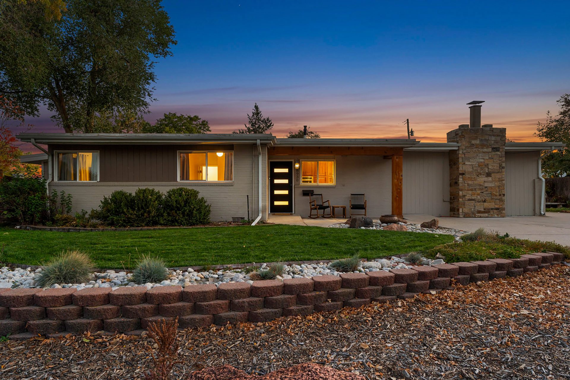 True Twilight exterior of luxury Colorado home with well-manicured lawn and pergola