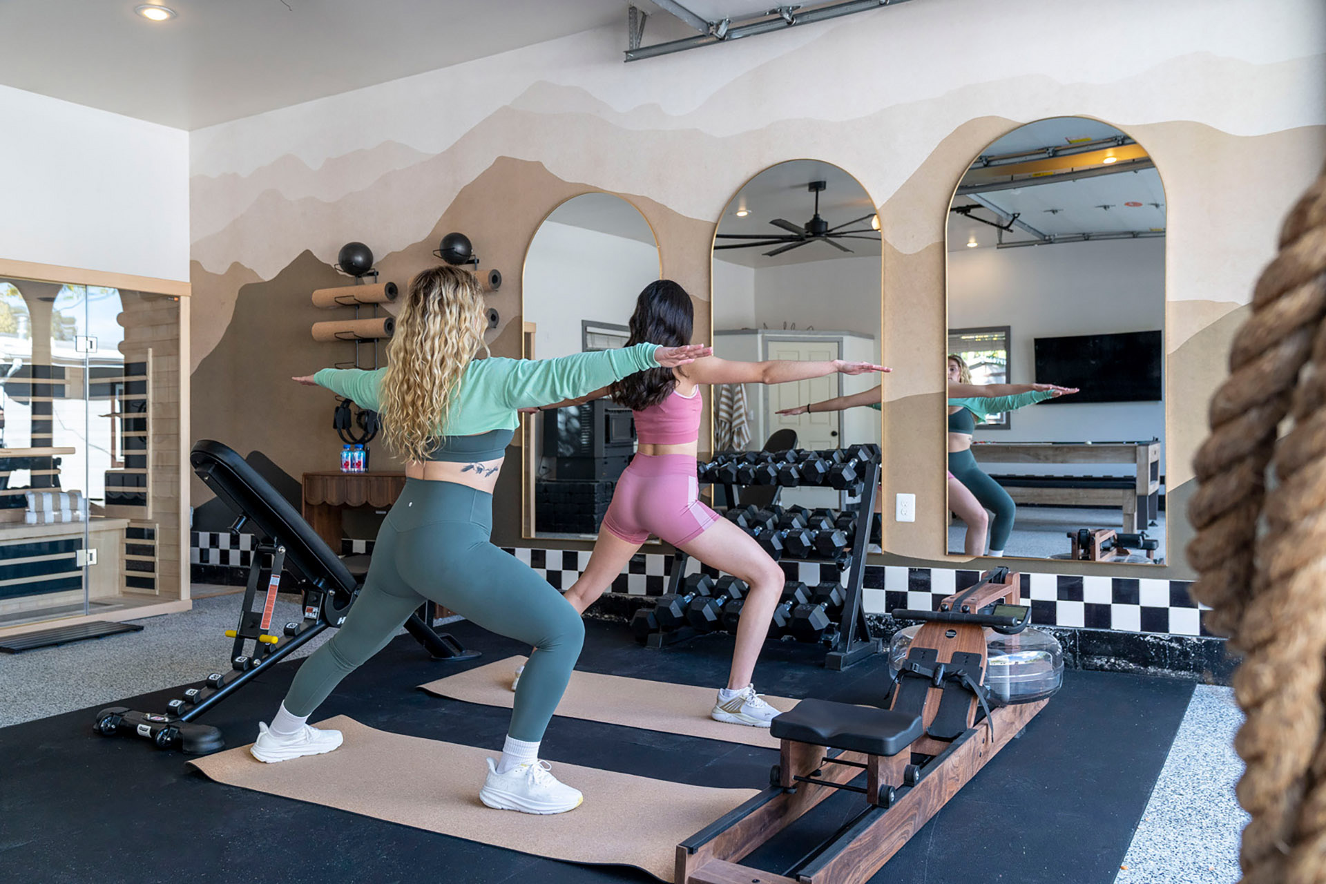 Two women exercising in home fitness studio with custom flooring and natural light